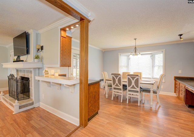 kitchen with baseboards, a breakfast bar, light wood-style flooring, and ornamental molding