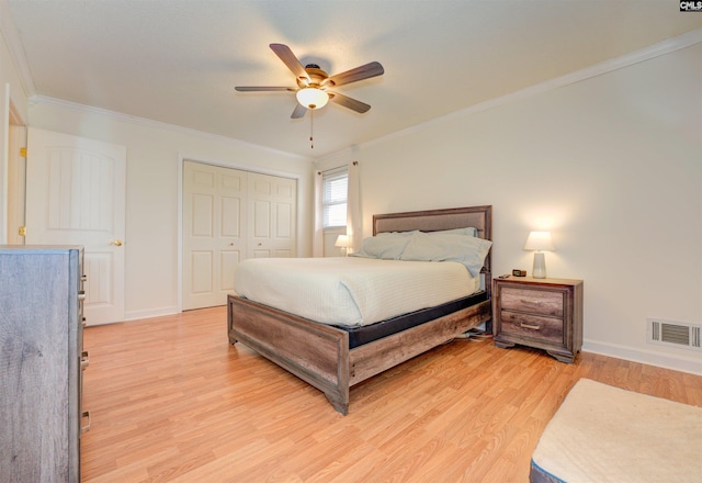 bedroom with light wood-type flooring, visible vents, a closet, crown molding, and baseboards