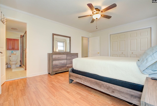 bedroom featuring a closet, light wood-style flooring, ensuite bath, and ornamental molding