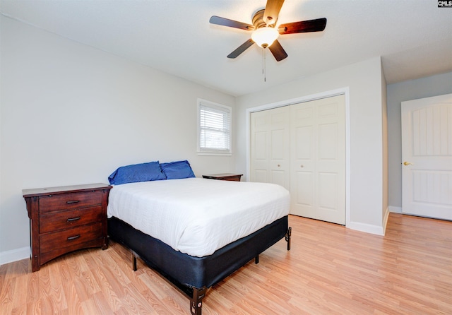 bedroom featuring a closet, baseboards, light wood-style floors, and a ceiling fan