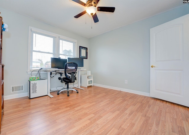 home office featuring light wood finished floors, visible vents, baseboards, and a ceiling fan