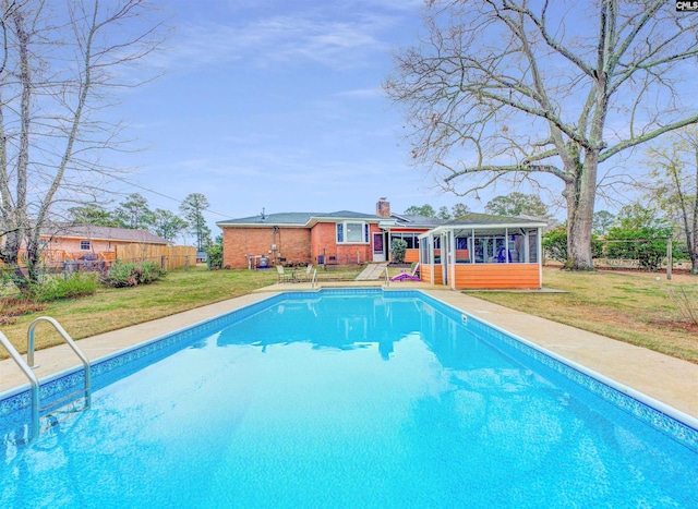 view of swimming pool with a fenced in pool, fence, a yard, and a sunroom