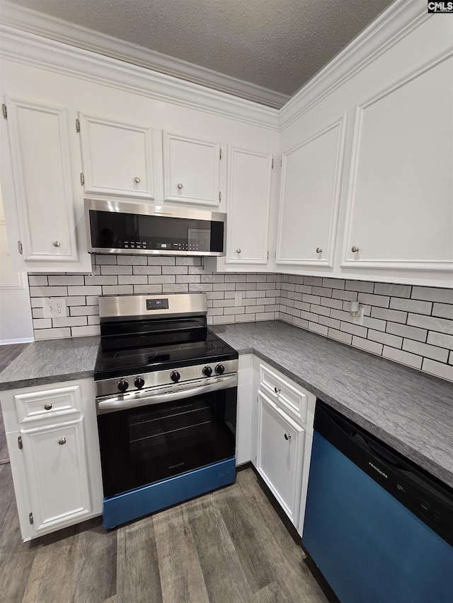 kitchen with backsplash, dark wood-type flooring, ornamental molding, stainless steel appliances, and white cabinetry