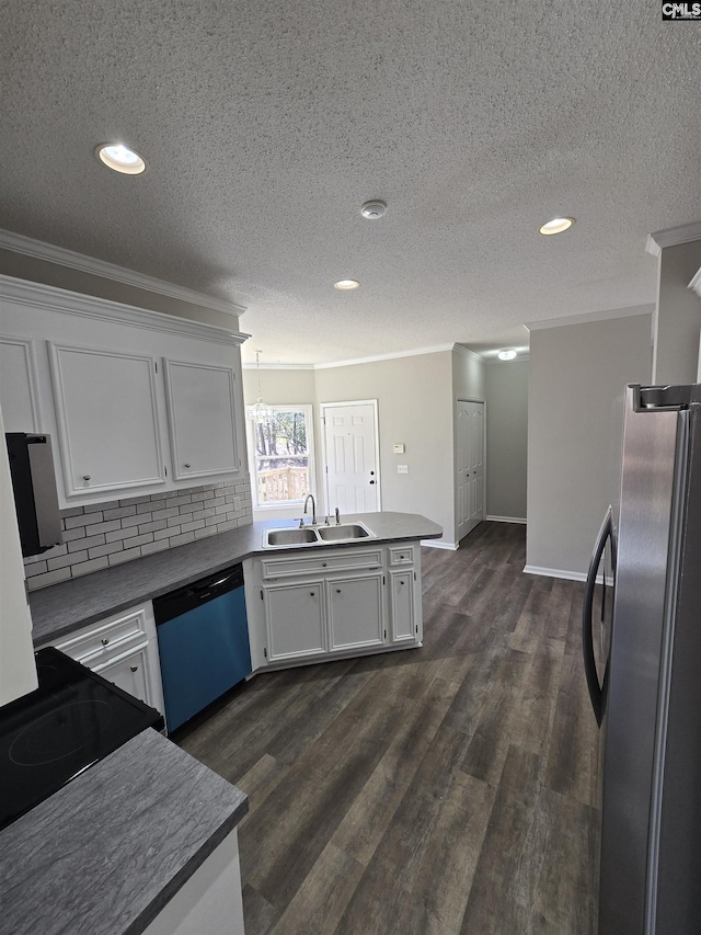 kitchen featuring dishwashing machine, a peninsula, freestanding refrigerator, a sink, and crown molding