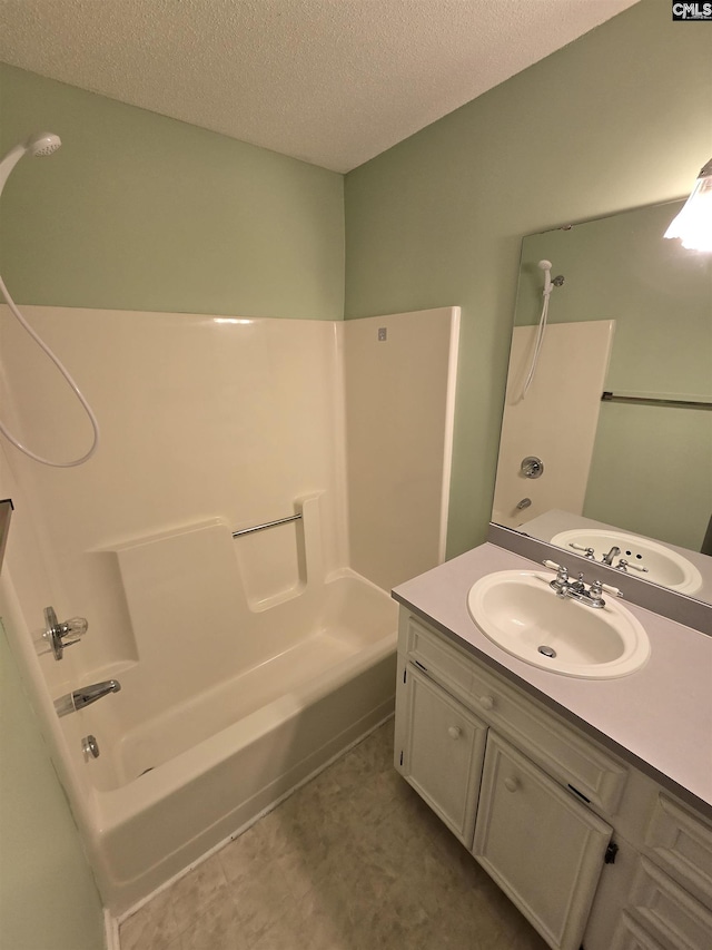 bathroom with vanity, a textured ceiling, and washtub / shower combination