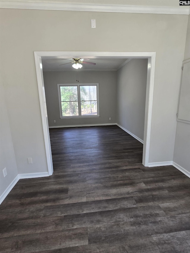 unfurnished room featuring baseboards, dark wood-type flooring, ceiling fan, and crown molding