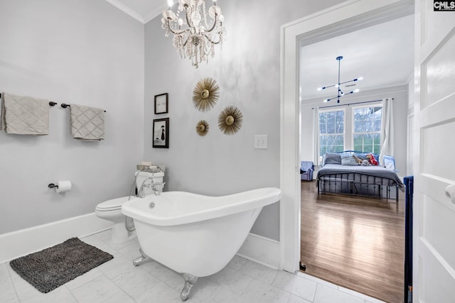 full bathroom featuring a chandelier, marble finish floor, crown molding, and a freestanding tub