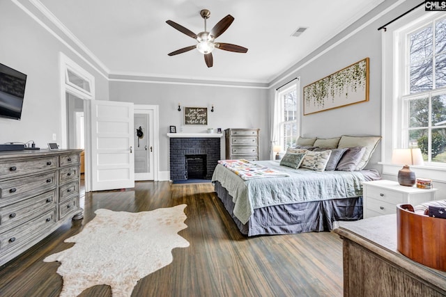 bedroom with crown molding, multiple windows, visible vents, and dark wood-style flooring