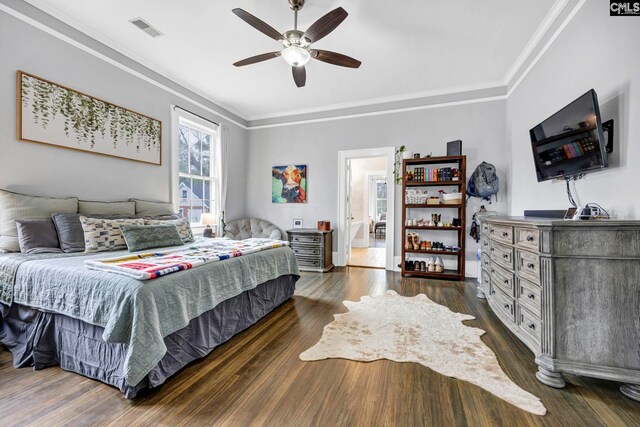 bedroom with dark wood finished floors, visible vents, ceiling fan, and ornamental molding