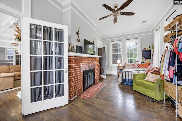 living area featuring a brick fireplace, wood finished floors, a ceiling fan, and ornamental molding