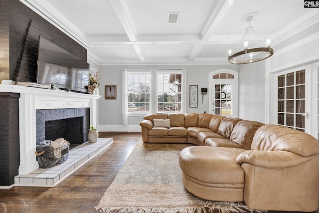 living room with visible vents, beam ceiling, an inviting chandelier, and wood finished floors