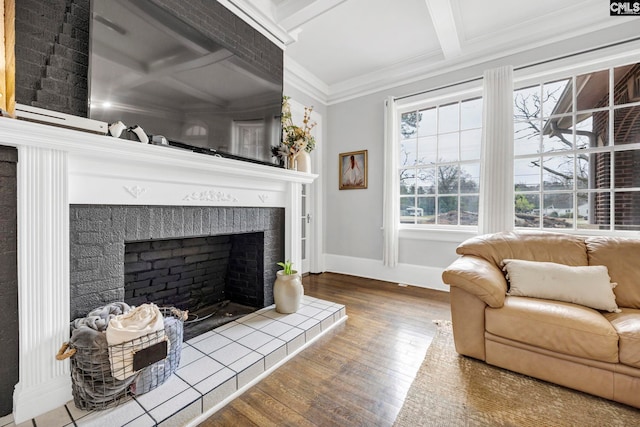 living room with hardwood / wood-style flooring, crown molding, coffered ceiling, and a tile fireplace