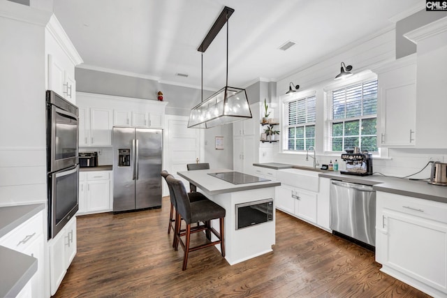 kitchen featuring dark wood-style floors, visible vents, ornamental molding, decorative backsplash, and appliances with stainless steel finishes