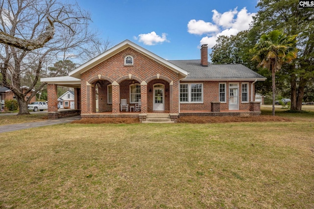 view of front of property with an attached carport, a front yard, a chimney, aphalt driveway, and brick siding