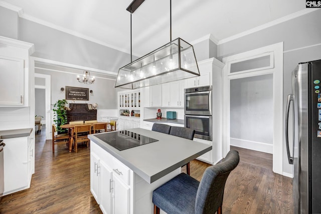 kitchen with a chandelier, white cabinets, appliances with stainless steel finishes, and crown molding