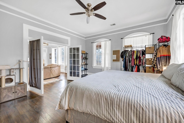 bedroom featuring visible vents, ceiling fan, ornamental molding, hardwood / wood-style flooring, and french doors