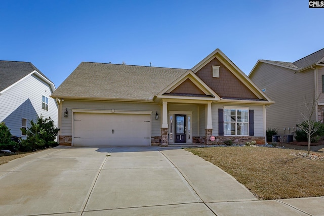 craftsman inspired home with an attached garage, stone siding, and driveway