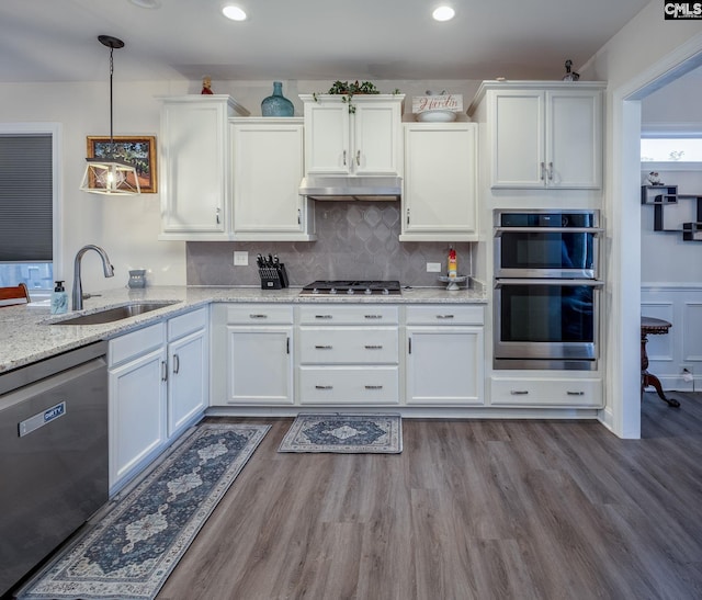 kitchen featuring a sink, white cabinets, under cabinet range hood, and stainless steel appliances