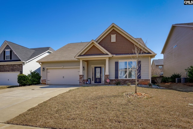 craftsman inspired home featuring central AC unit, an attached garage, concrete driveway, a front lawn, and stone siding