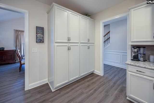 kitchen featuring dark wood-style floors, white cabinets, baseboards, and light stone counters