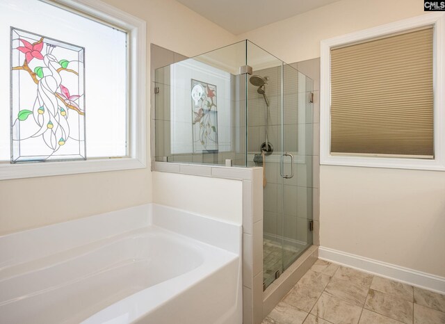 bathroom with baseboards, a bath, and a shower stall