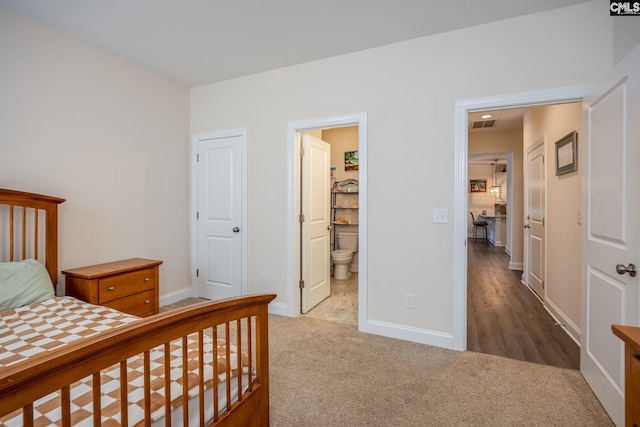 bedroom with visible vents, ensuite bath, baseboards, and carpet floors