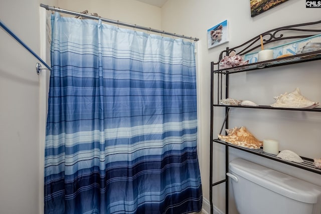 bathroom with a shower with curtain and toilet