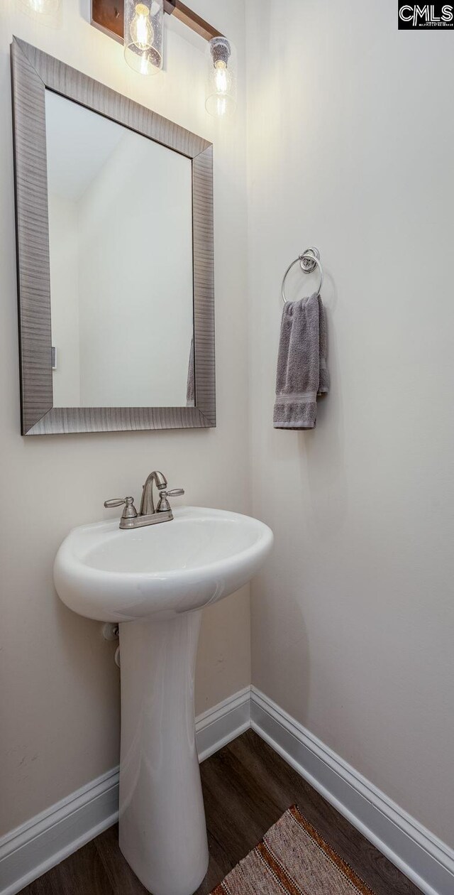 bathroom with a sink, baseboards, and wood finished floors