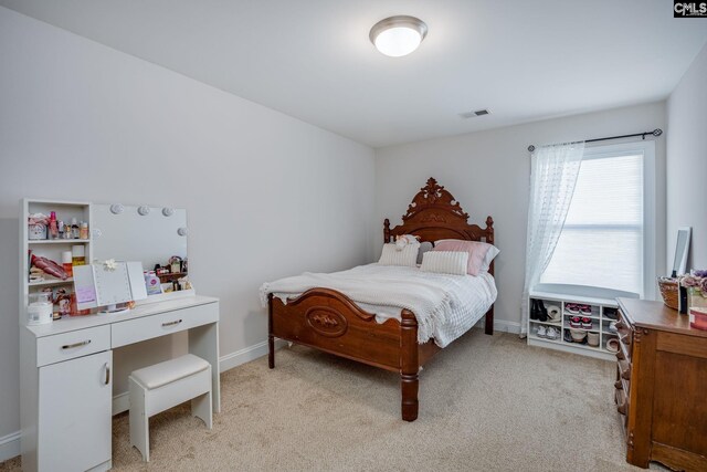 bedroom with light carpet, visible vents, and baseboards