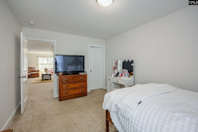 bedroom with light colored carpet and baseboards