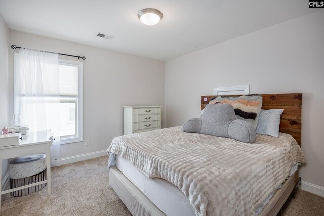 bedroom featuring visible vents, baseboards, and light colored carpet