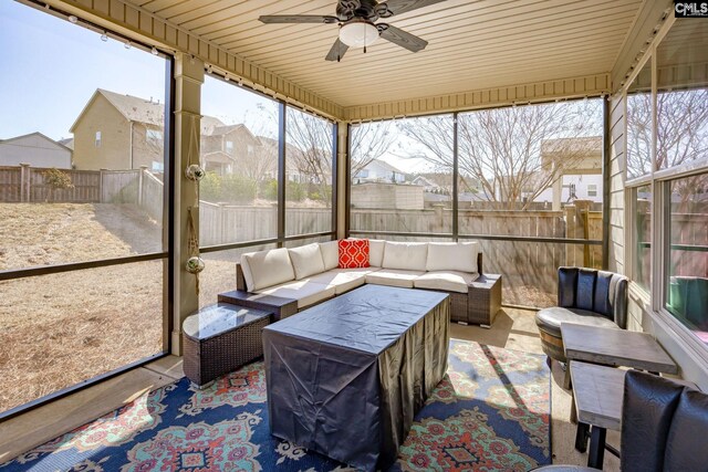 sunroom / solarium with a residential view, wooden ceiling, and a ceiling fan