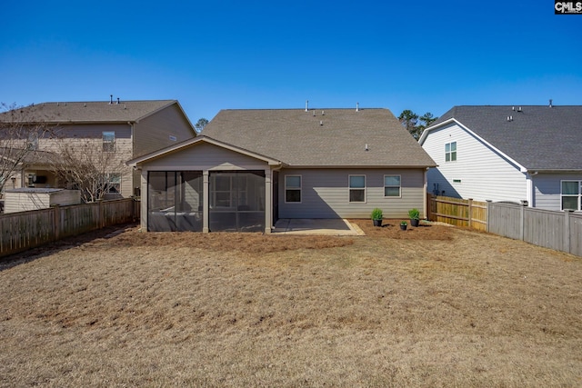 rear view of house with a patio area, roof with shingles, a fenced backyard, and a sunroom