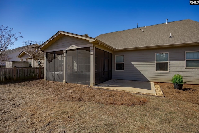 back of property with a patio, a sunroom, a shingled roof, and fence