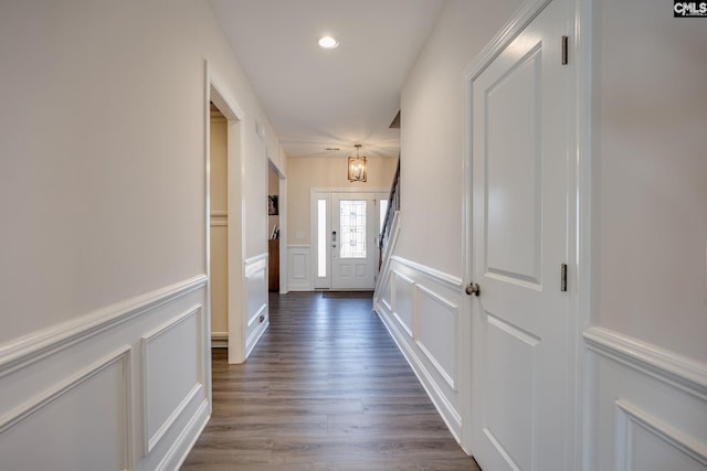 corridor with recessed lighting, dark wood-type flooring, and a decorative wall