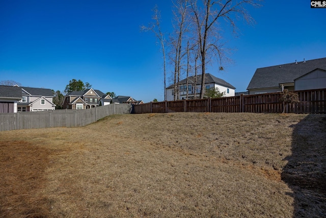 view of yard featuring a fenced backyard and a residential view