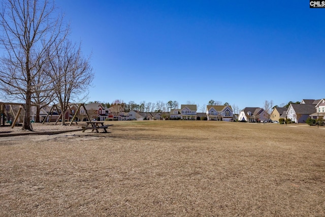 view of community featuring playground community, a residential view, and a yard