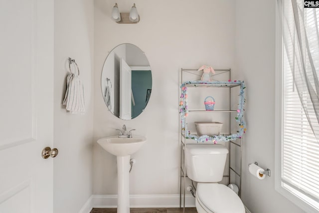 bathroom featuring toilet and baseboards