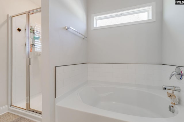 bathroom featuring a stall shower and a garden tub