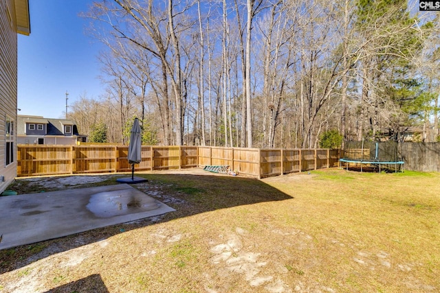 view of yard with a trampoline and a fenced backyard