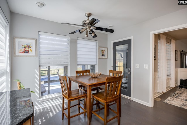 dining space with dark wood-style floors, baseboards, and ceiling fan