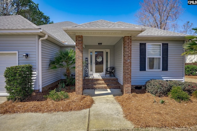 doorway to property with a porch and a shingled roof