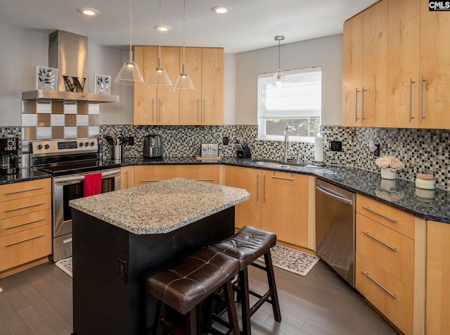 kitchen with dark wood-style floors, dark stone counters, light brown cabinetry, appliances with stainless steel finishes, and wall chimney exhaust hood