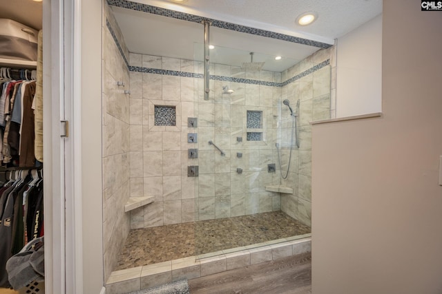 full bathroom with a spacious closet and a walk in shower