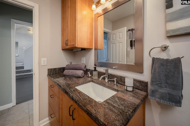 bathroom with tile patterned floors, vanity, and baseboards