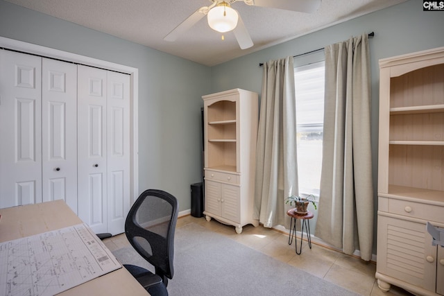 home office featuring light tile patterned floors, baseboards, a textured ceiling, and a ceiling fan