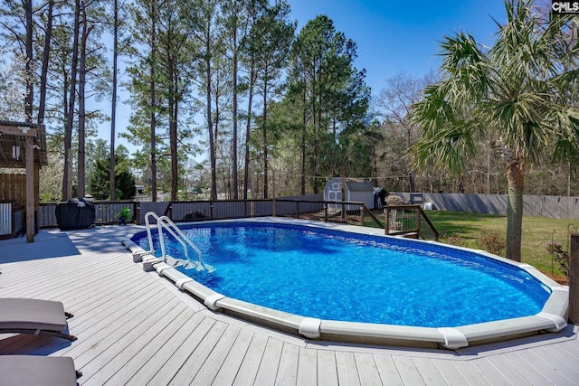 view of swimming pool with a deck, a fenced backyard, a fenced in pool, and a lawn