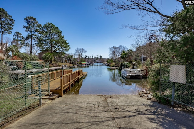 dock area with a water view and fence