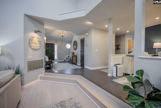 foyer entrance with wood finished floors, visible vents, baseboards, recessed lighting, and stairs