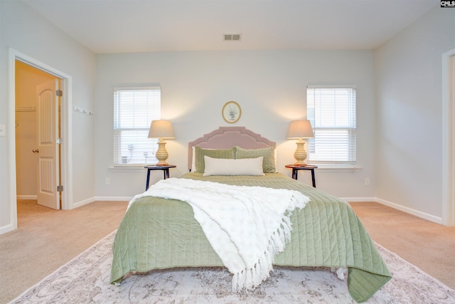 carpeted bedroom with multiple windows, baseboards, and visible vents